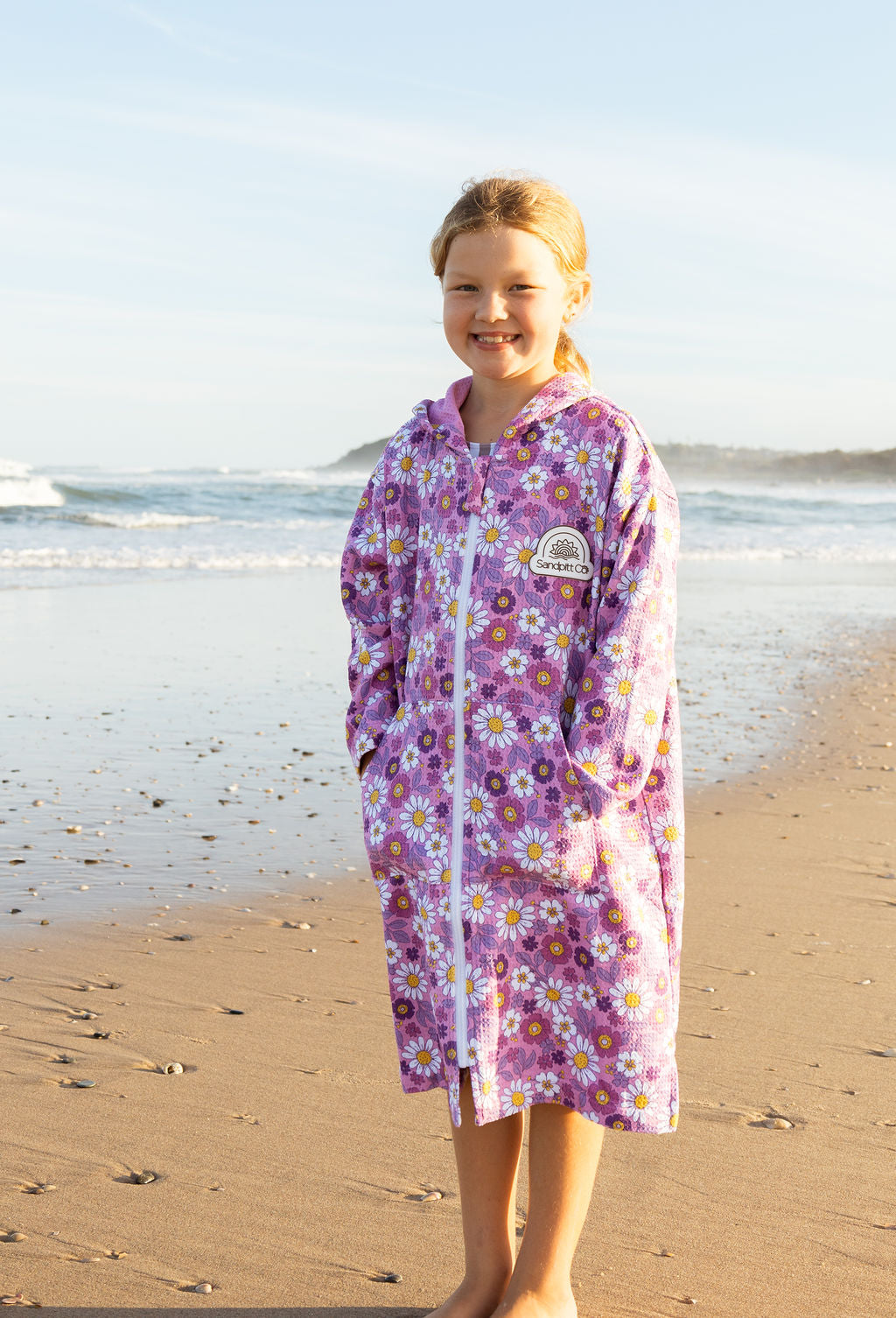 Child in Daisy 2.0 wearable towel (microfibre) at the beach